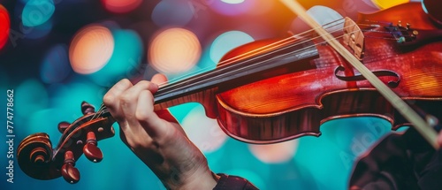 A violinist plays symphony music at a concert, with a close-up of her hand photo