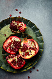 Vintage metal tray with a piece of fresh pomegranate. On a concrete background. Rustic style.