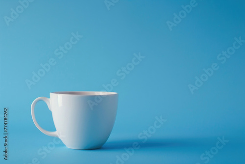 A single white coffee cup against a solid blue background
