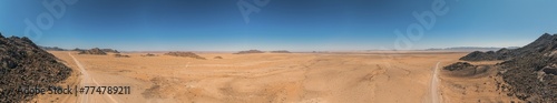 Panoramic drone picture of a lonely gravel road through the desert