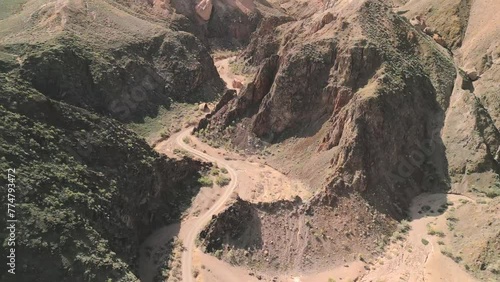 Charyn Canyon, Kazakhstan. Aerial drone view of the Sharyn National Park. Cinematic shot going down in between hills and rocks in famous travel landmark destination in Qazaqstan, Central Asia photo