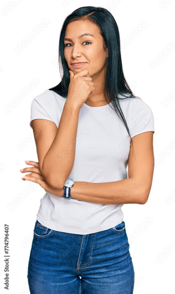 Beautiful hispanic woman wearing casual white tshirt with hand on chin thinking about question, pensive expression. smiling with thoughtful face. doubt concept. Beautiful hispanic woman wearing casual white tshirt with hand on chin thinking about question, pensive expression. smiling with thoughtful face. doubt concept.