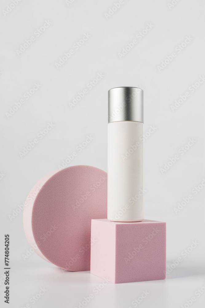 Plastic white tube for cream or lotion. Skin care or sunscreen cosmetic with stylish props on white background.