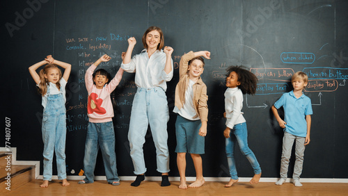 Multicultural happy student and teacher smiling and standing at blackboard with engineering code or prompt written. Kid express feeling of happy and enjoy with studying in STEM classroom. Erudition.