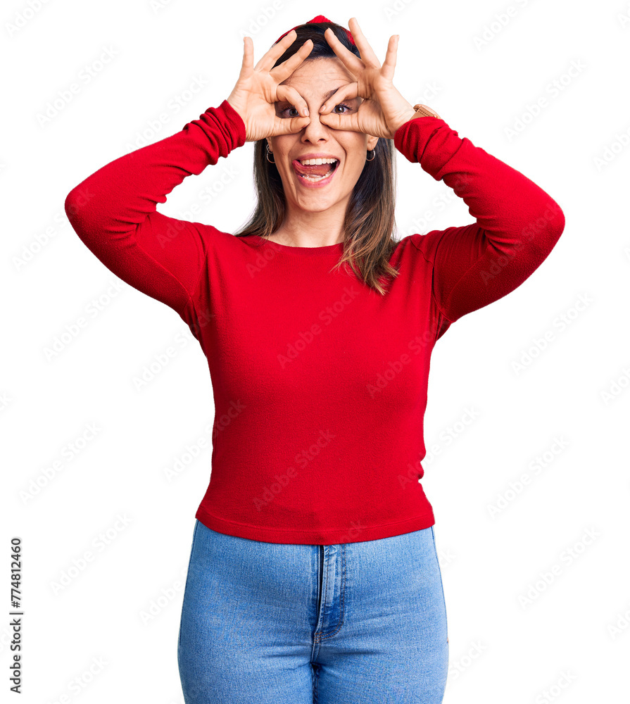 Young beautiful woman wearing casual clothes doing ok gesture like binoculars sticking tongue out, eyes looking through fingers. crazy expression. Young beautiful woman wearing casual clothes doing ok gesture like binoculars sticking tongue out, eyes looking through fingers. crazy expression.