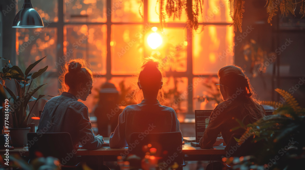 Silhouettes of workers in the office at sunset, view from the back. Silhouettes of workers in the office at sunset, view from the back.