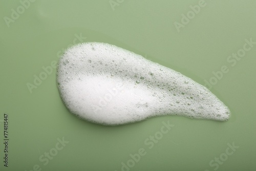 Sample of fluffy foam on green background, top view