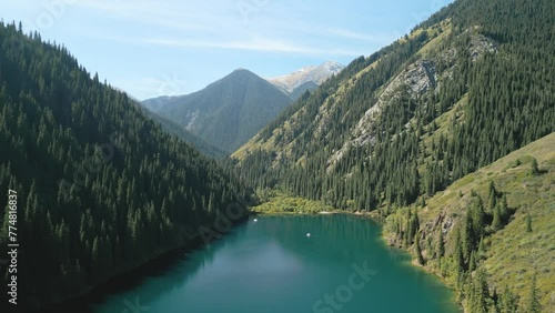 Aerial view of Kolsay Lake, Kulsa National Park, Kazakhstan. Cinematic backward drone shot of the amazing turquoise mountain lake. Famous landmark touristic destination in Central Asia mountains