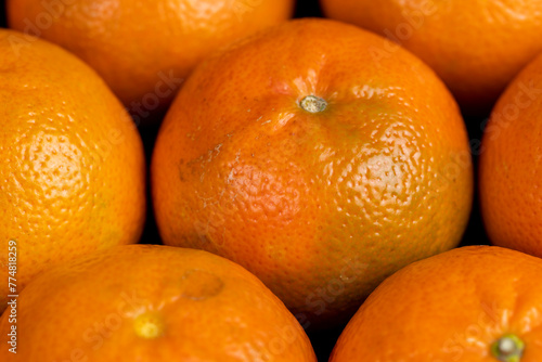 a large number of orange citrus fruits on a black slate surface