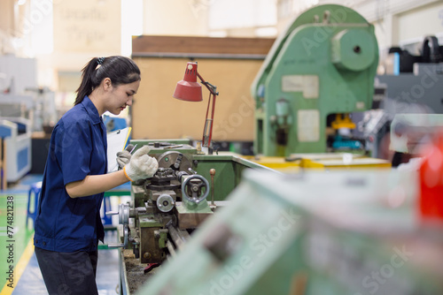 Asian women worker work in heavy industry with CNC lathe milling metal machine in steel product factory photo