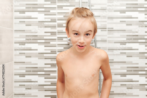 Cute child washing himself in shower.