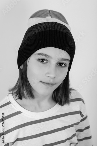 Cute boy wearing stylish woolen hat. Face portrait of eleven years old kid.
