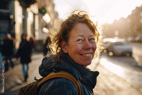 Portrait of smiling senior woman in the city streets at sunset.
