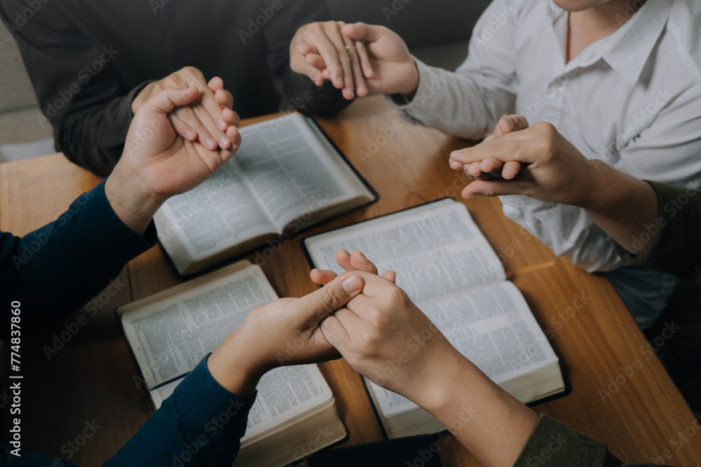 Obraz premium Christian group holding hands pray and worship god together on the sunday morning.spirituality, religion,believe.Christian life.Studying the word of God in church.