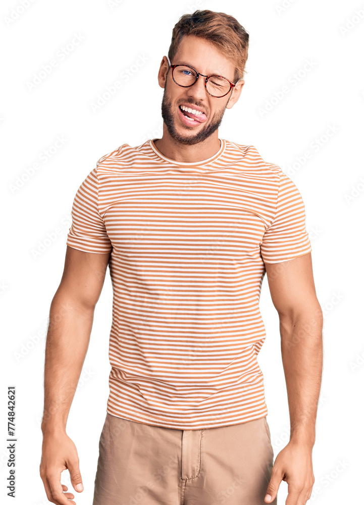 Young caucasian man wearing casual clothes and glasses winking looking at the camera with sexy expression, cheerful and happy face. Young caucasian man wearing casual clothes and glasses winking looking at the camera with sexy expression, cheerful and happy face.