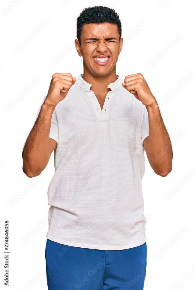 Young arab man wearing casual clothes excited for success with arms raised and eyes closed celebrating victory smiling. winner concept. Young arab man wearing casual clothes excited for success with arms raised and eyes closed celebrating victory smiling. winner concept.