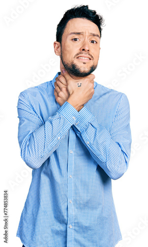 Hispanic man with beard wearing casual business shirt shouting and suffocate because painful strangle. health problem. asphyxiate and suicide concept.
