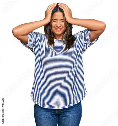 Young latin girl wearing casual clothes suffering from headache desperate and stressed because pain and migraine. hands on head.