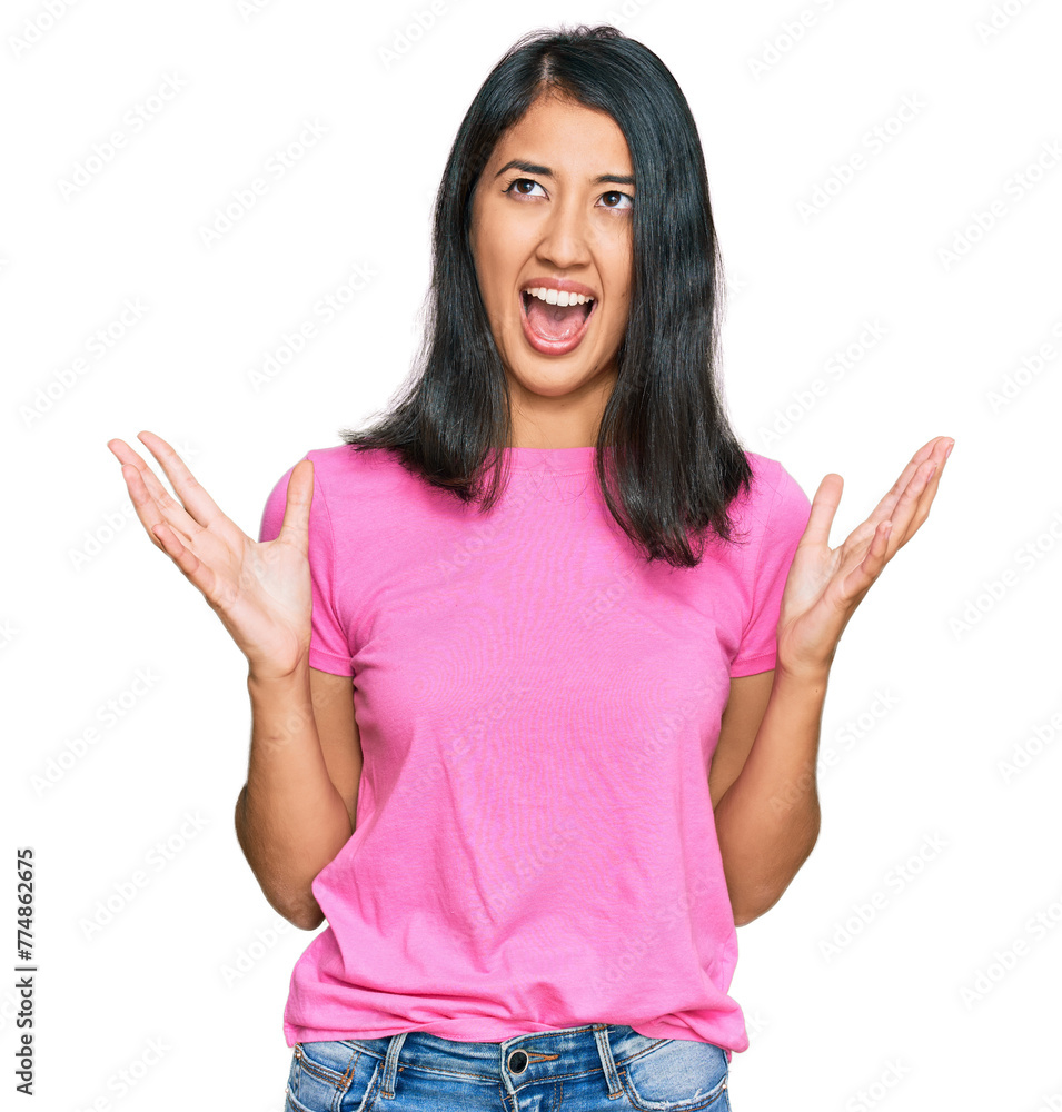 Beautiful asian young woman wearing casual pink t shirt crazy and mad shouting and yelling with aggressive expression and arms raised. frustration concept. Beautiful asian young woman wearing casual pink t shirt crazy and mad shouting and yelling with aggressive expression and arms raised. frustration concept.