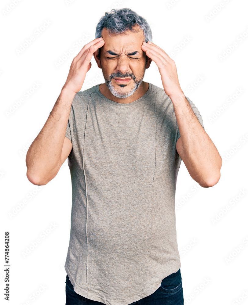 Middle age hispanic with grey hair wearing casual grey t shirt with hand on head for pain in head because stress. suffering migraine. Middle age hispanic with grey hair wearing casual grey t shirt with hand on head for pain in head because stress. suffering migraine.