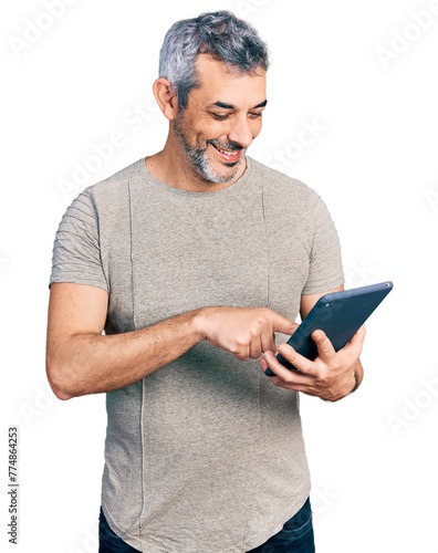 Middle age hispanic with grey hair using touchpad device smiling with a happy and cool smile on face. showing teeth. photo