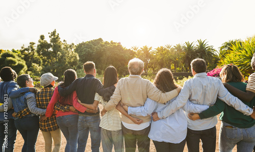 Group of multigenerational people hugging each others - Support, multiracial and diversity concept - Main focus on senior man with white hairs