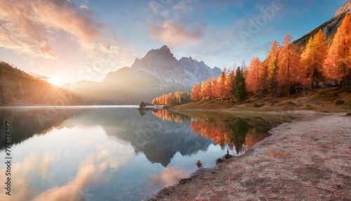 first sunlight glowing hills of federa lake spectacular sunrise in dolomite alps with orange larch trees on the shore colorful morning scene of italy europe beauty of nature concept background © Claudio