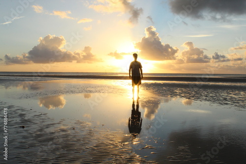 silhueta de homem em nascer do sol na praia de tatuamunha, alagoas  photo