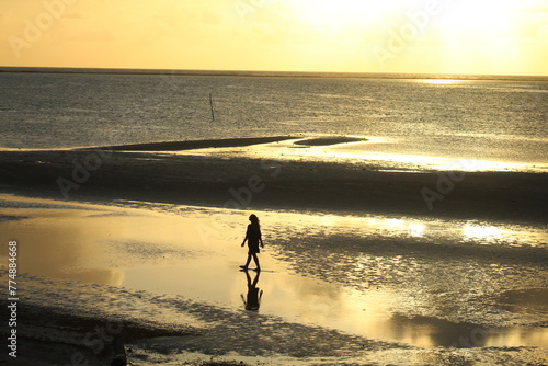 silhueta de mulher em nascer do sol na praia de japaratinga, alagoas  photo