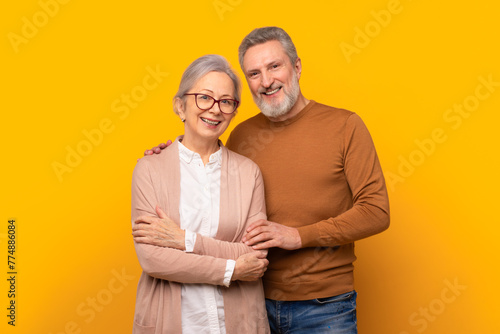 Studio shot of loving happy senior couple posing together embracing