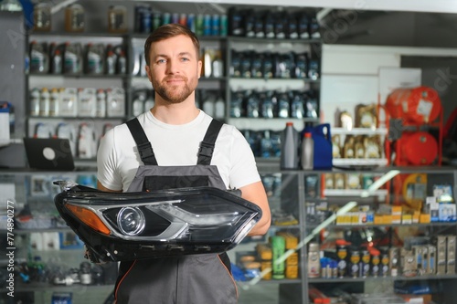 man holds automotive headlight in auto parts store photo