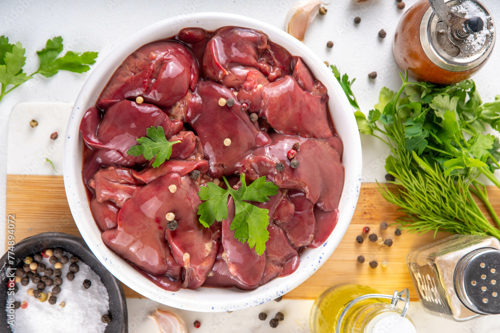 Raw chicken, turkey, duck, poultry liver with herbs and spices. Poultry liver dinner cooking background, diet food copy space