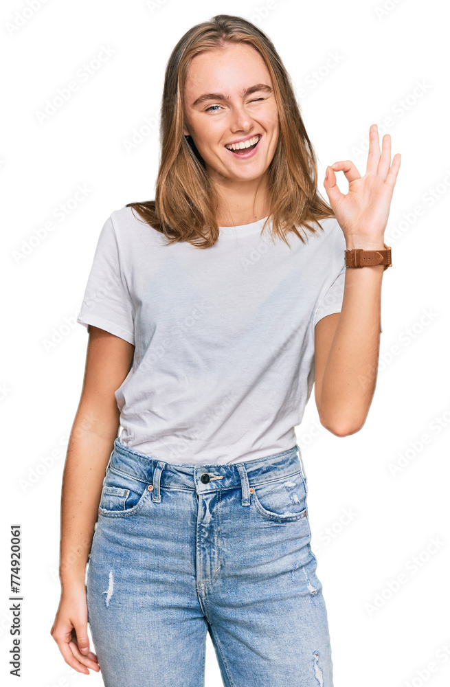 Fototapeta premium Beautiful young blonde woman wearing casual white t shirt smiling positive doing ok sign with hand and fingers. successful expression.