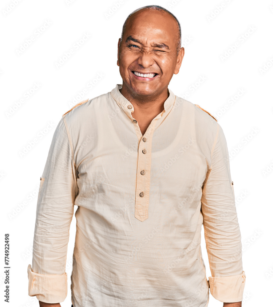 Hispanic middle age man wearing boho shirt winking looking at the camera with sexy expression, cheerful and happy face. Hispanic middle age man wearing boho shirt winking looking at the camera with sexy expression, cheerful and happy face.
