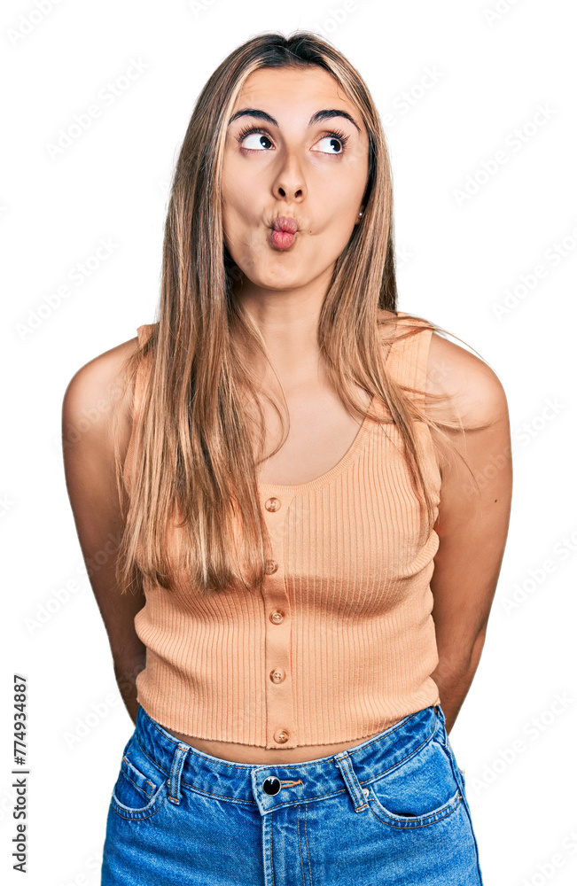 Hispanic young woman wearing casual summer shirt making fish face with lips, crazy and comical gesture. funny expression. Hispanic young woman wearing casual summer shirt making fish face with lips, crazy and comical gesture. funny expression.
