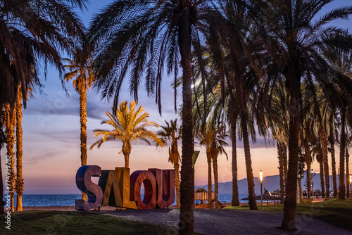 colorful letters of Salou town, palm trees andl beach at sunset, Catalonia, Spain photo