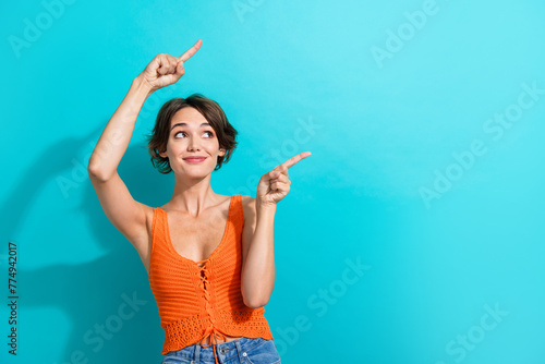 Photo of pleasant gorgeous woman dressed knitwear singlet indicating look at logo empty space isolated on turquoise color background
