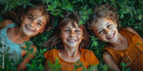 Cheerful, laughing friends lying on the grass in a forest, enjoying playful summer joy.