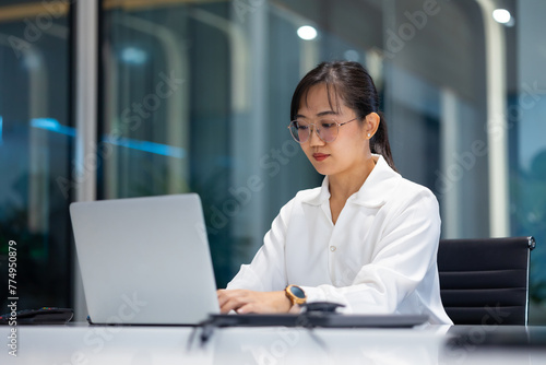 working woman - business woman busy working on laptop computer at moder office workspace. Attractive beautiful Asian business woman working in home office.