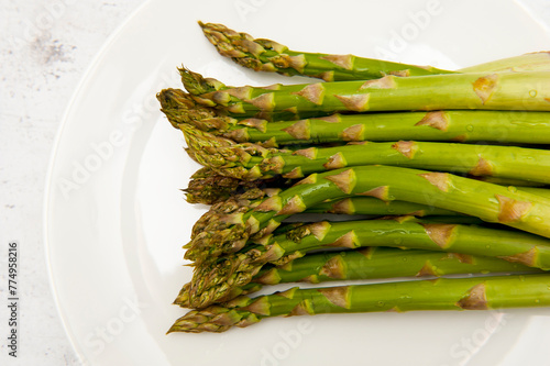 Top view of green asparagus on white plate