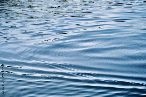 Gently undulating waves create a serene water abstract solid background, reflecting the subtle movement of a calm, tranquil lake.