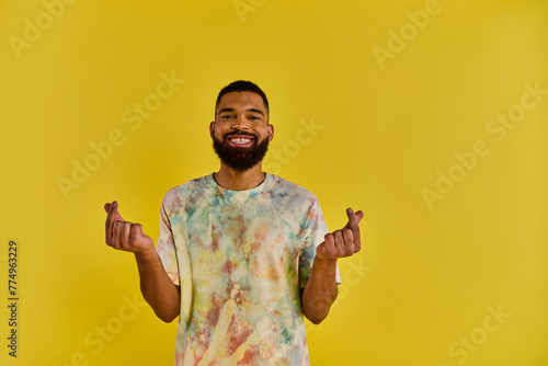 A lone man stands stoically in front of a vibrant yellow background, capturing the contrast between his figure and the bold color behind him.