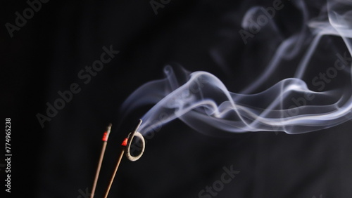 Burning incense sticks on a dark background photo