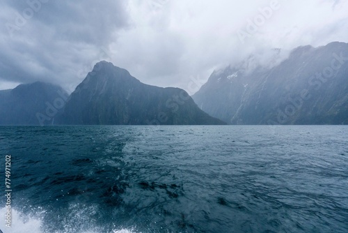 Fiordland National Park with seascape view  cloudy and foggy mountains background