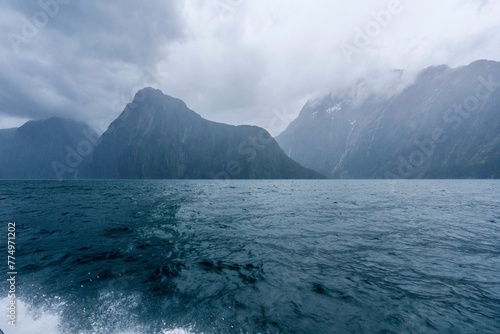 Canvas Print Fiordland National Park with seascape view, cloudy and foggy mountains backgroun