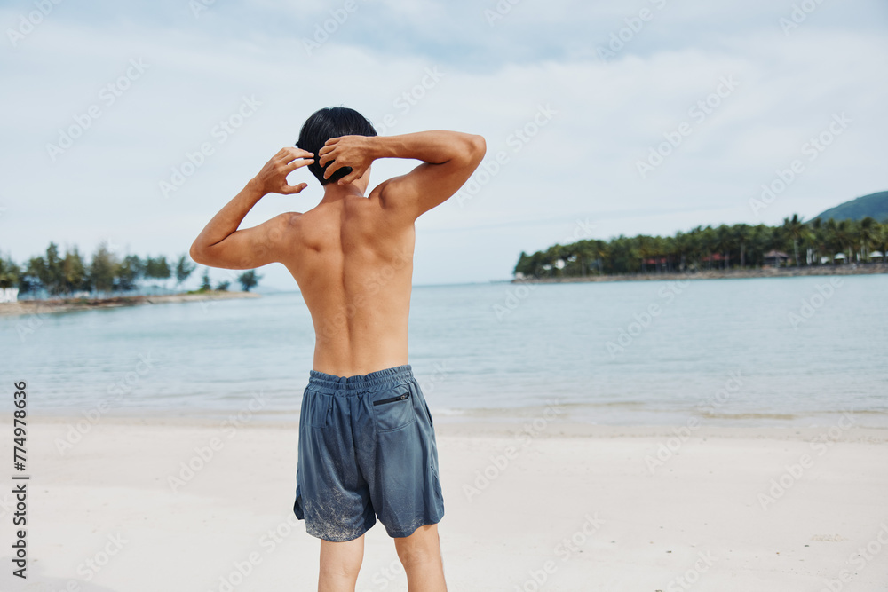 Active Asian Man Enjoying Sunset Beach Run in Healthy Lifestyle
