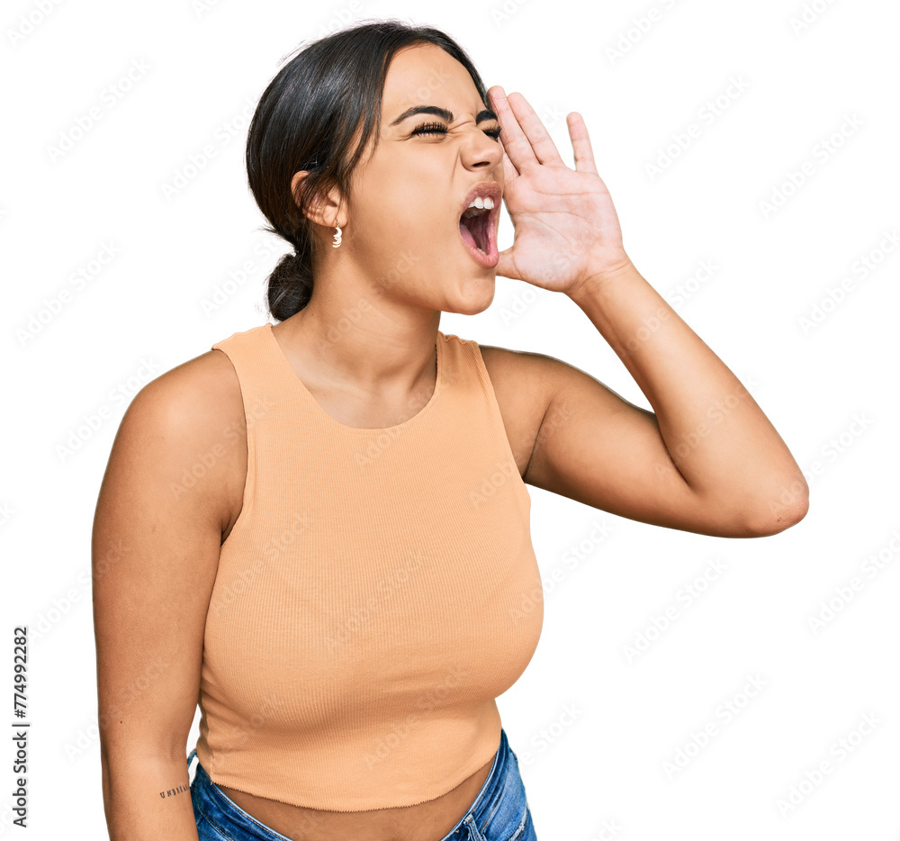 Young brunette woman wearing casual clothes shouting and screaming loud to side with hand on mouth. communication concept. Young brunette woman wearing casual clothes shouting and screaming loud to side with hand on mouth. communication concept.
