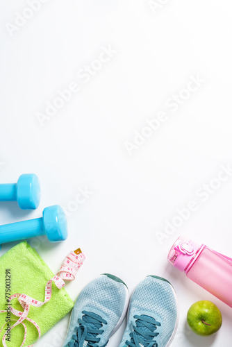 Sneakers, dumbbells, green apple and bottle of water isolated on white background.