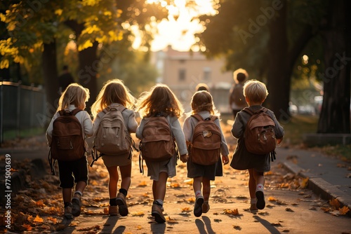 Group of elementary school children walks in school, rear view.