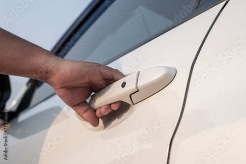 Hand on handle. Close-up of man in opening a car door. © yotrakbutda
